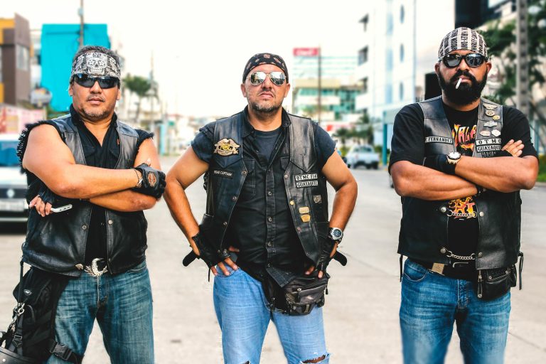 Three bikers in vests and sunglasses posing confidently on a street in Guayaquil, Ecuador. for blog on what is an outlaw motorcycle club for outlaw biker myths page